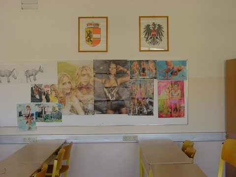 Das Salzburger Landeswappen und das Wappen der Republik Österreich über den Porno-Plakaten im Klassenzimmer